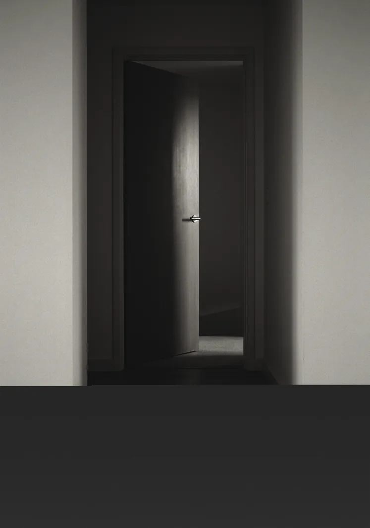 Puerta de una vivienda entreabierta en penumbra